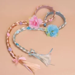 Prinsesseparyk med lange fletninger og hårbånd, med blå blomster og hvide fletninger.